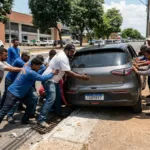 Grupo de homens se mobiliza para retirar carro preso em bueiro em Goiânia